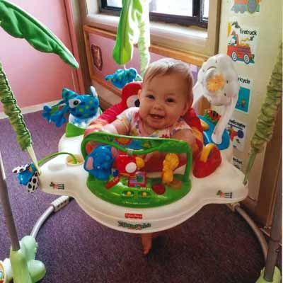 an infant sitting in a toy sci fi chair at a daycare